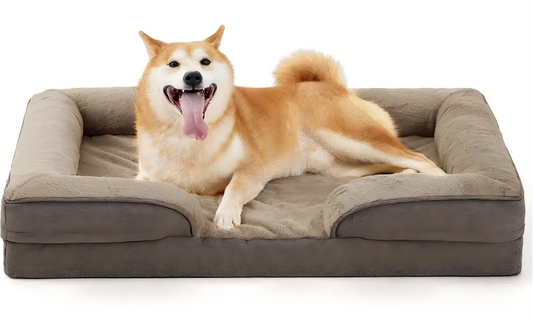 Happy dog lying comfortably on a plush gray dog sofa bed with raised edges