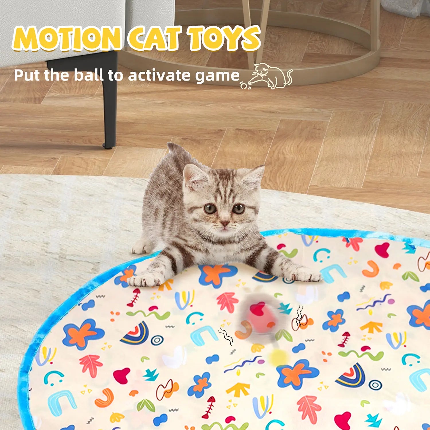 Gray kitten playing with FelRelWel automatic cat toy ball on colorful activity mat indoors