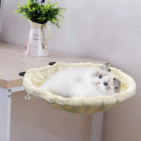 FelRelWel cat desk bed with soft cream cushion attached to a wooden desk holding a relaxed white and gray cat